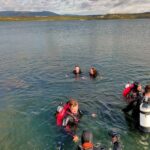 Skupina lidí v potápěčské výstroji prozkoumává podmořský svět Jezero Most.